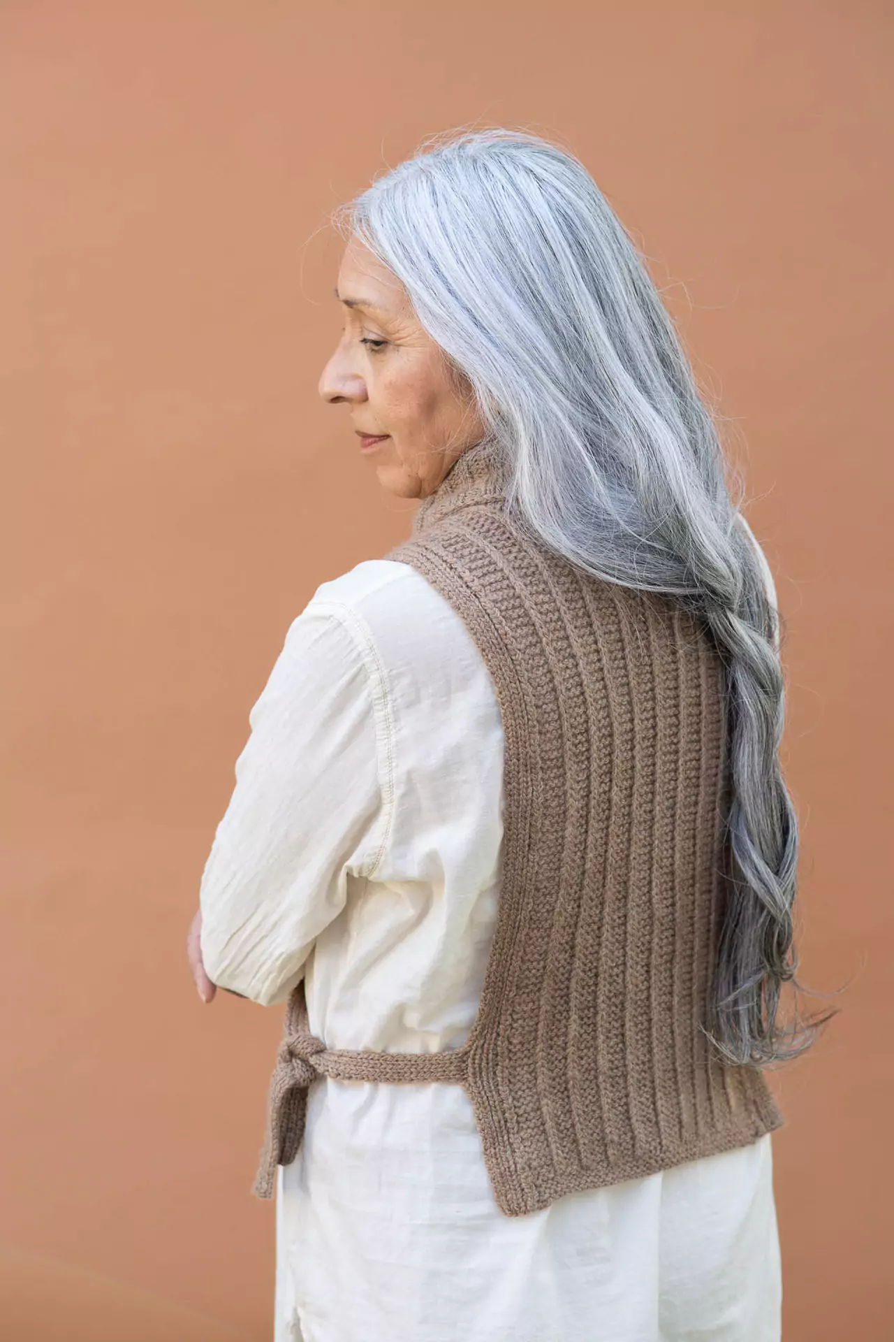 View of a mature silver haired woman's back showing the texture of a knitted dickey accessory
